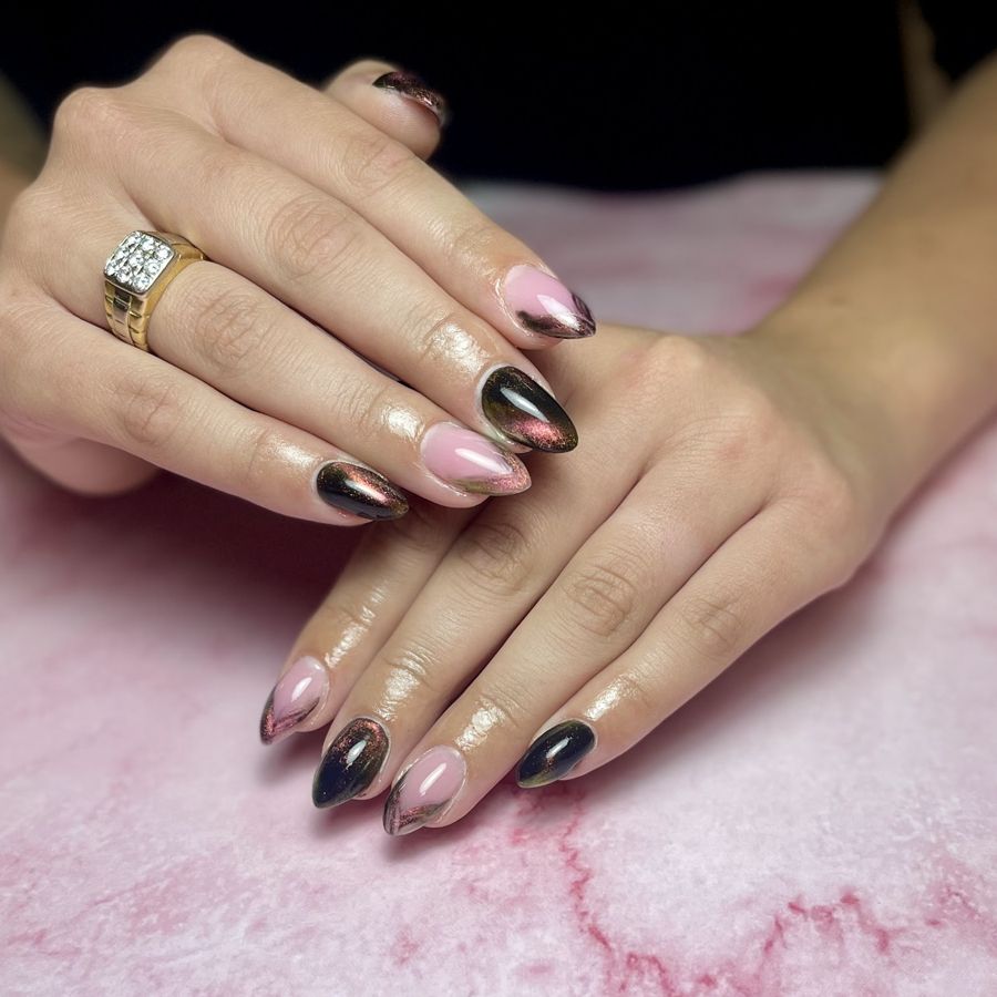 Amandelnagels afwisselend zwart met een metaalglans en roze met donkere punt, op roze marmer
